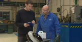2 hommes sont en train de discuter dans un atelier