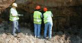 Groupe de 3 experts en train d'étudier les traces de pollution dans le sol