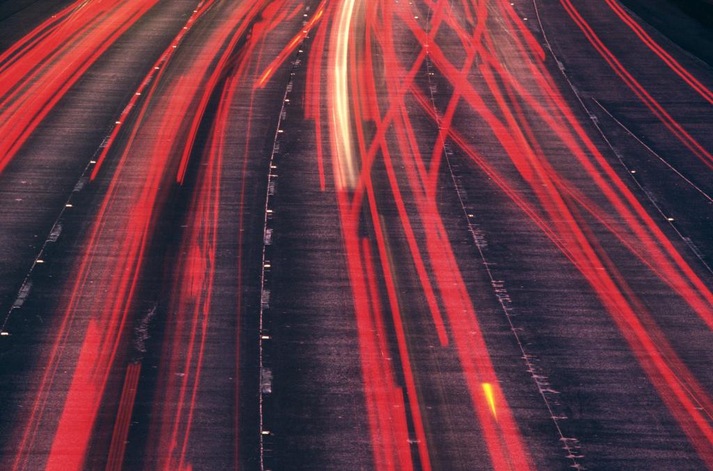 photo montrant les lignes de lumières rouges correspondant aux phares des voitures de nuit